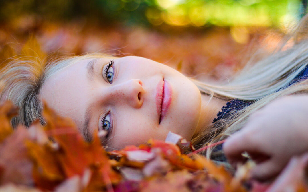 portrait d'une belle fille sans maquillage permanent couchée dans les feuilles colorées d'automne