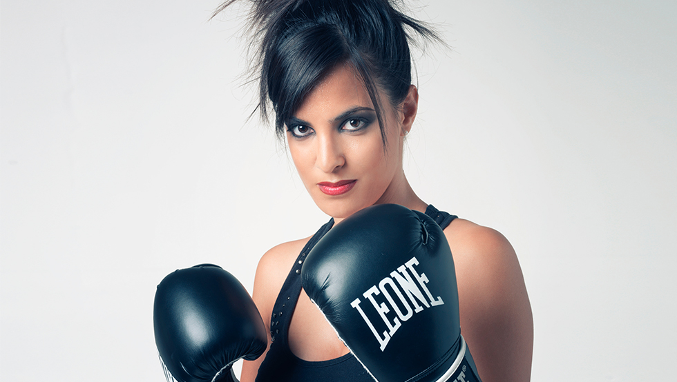 femme brune avec des gants de boxe combatant la concurrence en maquillage permanent suisse